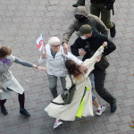 ９日、ミンスクの街頭で、若者をいきなり拘束するベラルーシの警官と、止めに入る市民（ＥＰＡ時事）