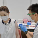 ワクチンを打つ自衛隊の医官　=２５日午前、新型コロナウイルスワクチン大規模接種センター大阪会場