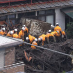 大規模な土石流が発生した伊豆山地区で、家屋に流れ込んだ土砂を撤去する消防隊員ら＝４日午後、静岡県熱海市
