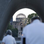 被爆76年目を迎える朝、平和記念公園の原爆死没者慰霊碑を訪れ祈りをささげる人たち＝6日午前、広島市中区