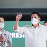 新型コロナウイルスワクチンの瓶を持つフィリピンのシャヒーン氏 ドゥテルテ大統領＝３月４日、マニラ（ＡＦＰ時事）