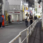 歌舞伎町を歩く、路上の女性に寄り添う捜査員