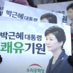 24日、ソウル市内の病院前で開かれた朴槿恵元大統領赦免を歓迎する集会で写真入りプラカードを掲げる参加者たち（韓国のニュース番組から）