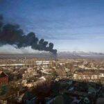 ２４日、ウクライナ東部ハリコフ近郊の軍用飛行場から上がる黒い煙（ＡＦＰ時事）