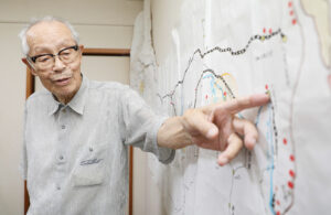 収容所やシベリア鉄道の路線図が描かれた手作りの地図を示す近田明良さん（7月28日、東京都福生市）