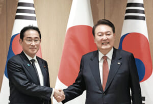 会談の冒頭、握手する岸田文雄首相（左）と韓国の尹錫悦大統領＝７日、ソウル大統領府（時事）