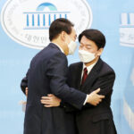 ３日、ソウルで、保守系最大野党「国民の力」の尹錫悦氏（左）支持を表明後、同氏と抱き合う保守中道野党「国民の党」の安哲秀氏（ＥＰＡ時事）